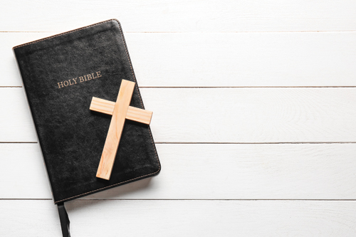 Bible with a wooden cross on top