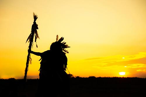 The Indians are riding a horse and spear ready to use In light o