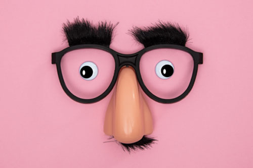 Funny face mask on pink background